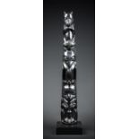 A LARGE 20TH CENTURY HAIDA ARGILLITE TOTEM POLE CARVING MUSEUM REPLICA IN RESIN. At the base a
