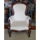A VICTORIAN STYLE MAHOGANY SPOON BACK ARMCHAIR Upholstered in a cream water silk, raised on turned