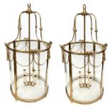 A PAIR OF BRASS LANTERNS IN THE REGENCY STYLE With four glass sections and rope twist swags above