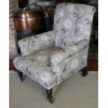 A 19TH CENTURY EASY ARMCHAIR In oatmeal floral fabric upholstery, raised on turned and fluted legs