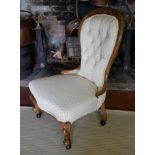 A VICTORIAN MAHOGANY SPOON BACK NURSING CHAIR Button back cream fabric upholstery, raised on