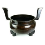 A VERY LARGE ORIENTAL BRONZE CENSER Having two archaic shaped handles, supported by three temple