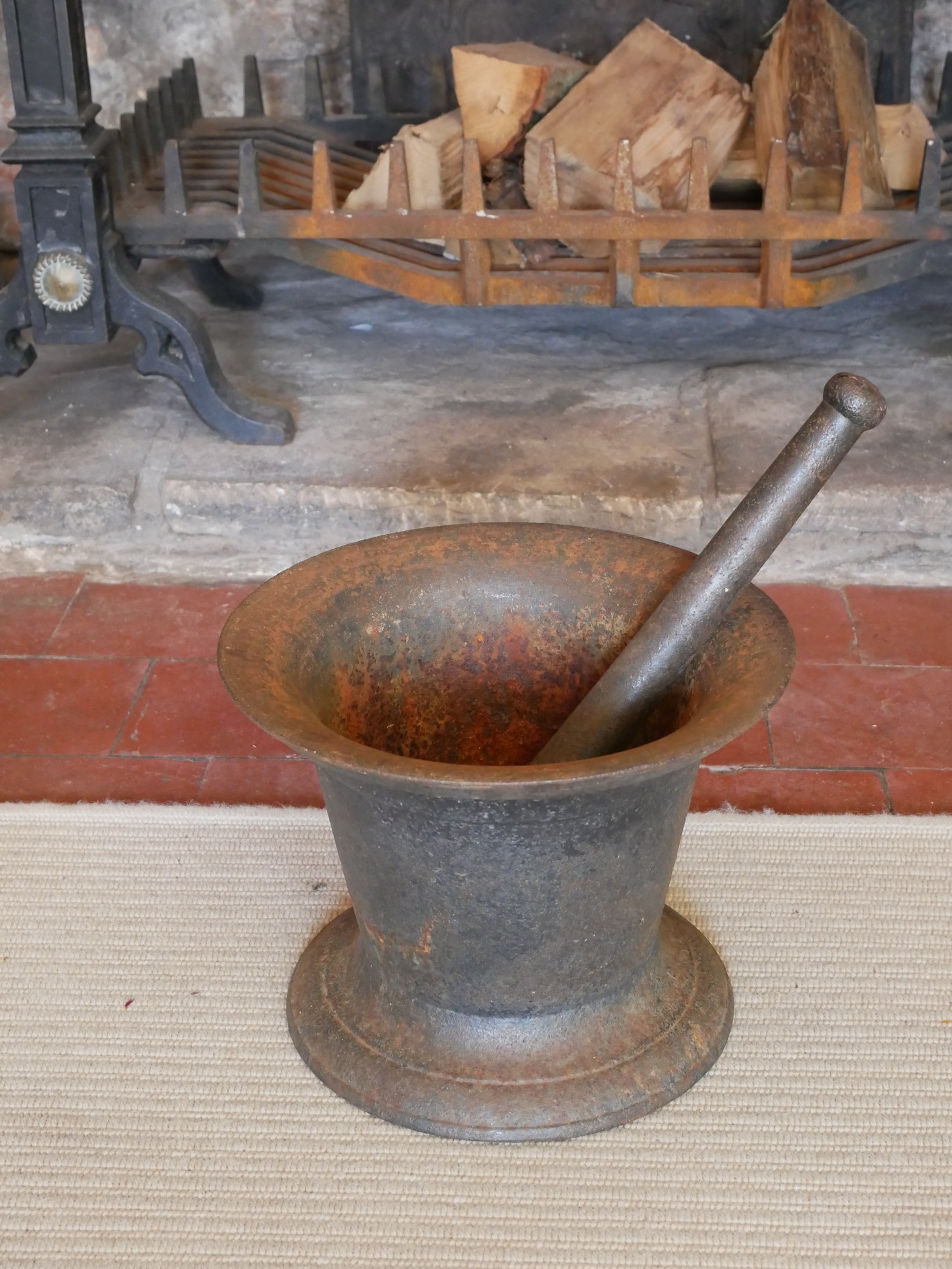 A LARGE 19TH CENTURY CAST IRON PESTLE AND MORTAR Classical bell form, on a circular base. (approx