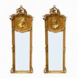 A PAIR OF DECORATIVE GILT FRAMED PIER MIRRORS With cartouches above female portraits and shaped