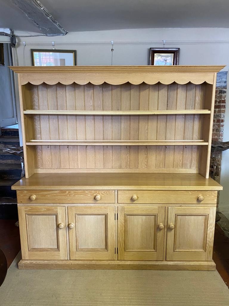 A VICTORIAN STYLE LIMED OAK DRESSER With open shelves above two long drawers and four cupboards,