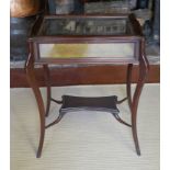 A LATE VICTORIAN MAHOGANY BIJOUTERIE TABLE With cartouche shaped top glazed top enclosing a velvet