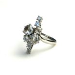 A VINTAGE WHITE METAL AND DIAMOND EIGHT STONE CLUSTER RING The arrangement of round cut diamonds (