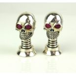 A PAIR OF SILVER PLATED NOVELTY 'SKULL' SALT POTS Having red glass eyes and screw bases. (approx 4.
