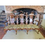 AN 18TH CENTURY IRISH WALNUT CHAIR BACK THREE SEAT SETTEE With carved and plain panelled back