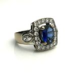 A FRENCH 18CT WHITE GOLD, SAPPHIRE AND DIAMOND RING The single oval cut sapphire edged with round
