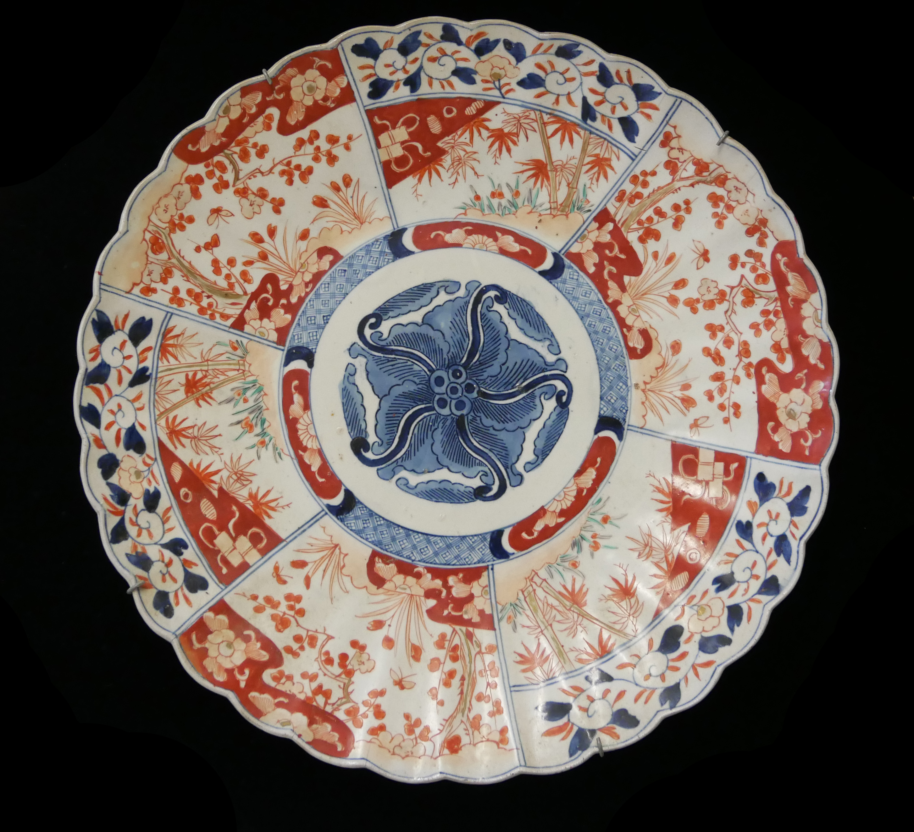 A 19TH CENTURY JAPANESE IMARI PORCELAIN CHARGER PLATE Chrysanthemum form with underglaze blue and