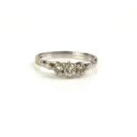 A VINTAGE 18CT WHITE GOLD AND DIAMOND THREE STONE RING Three graduated round cut stones in a plain