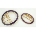 TWO EARLY 20TH CENTURY YELLOW METAL AND ENAMEL OVAL BUCKLES With purple enamel decoration. (larger