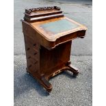 A VICTORIAN WALNUT DAVENPORT DESK With pierced galleried back above fitted writing section and