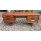 AUSTINSUITE, A MID CENTURY TEAK DESK/DRESSING TABLE Designed by Frank Guille, with two banks of