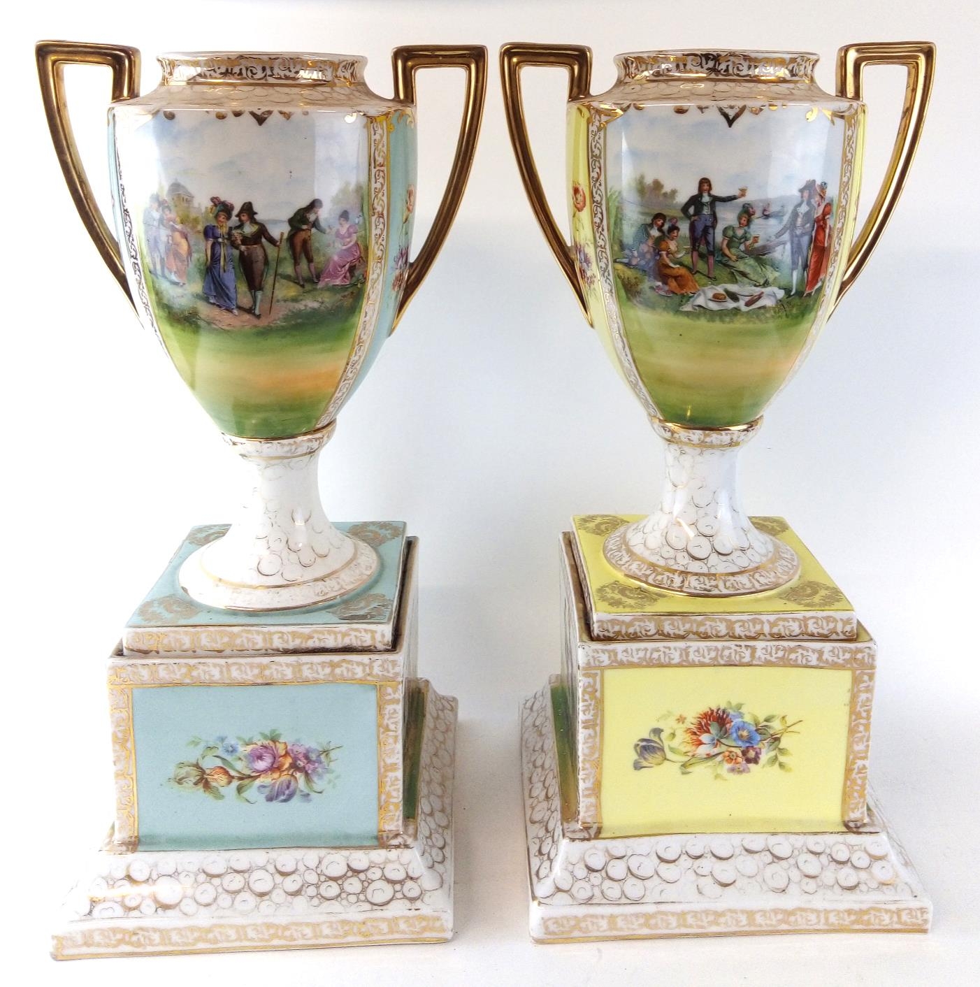A LARGE PAIR OF EARLY 20TH CENTURY AUSTRIAN PORCELAIN PEDESTAL VASES Campagna form with twin gilt