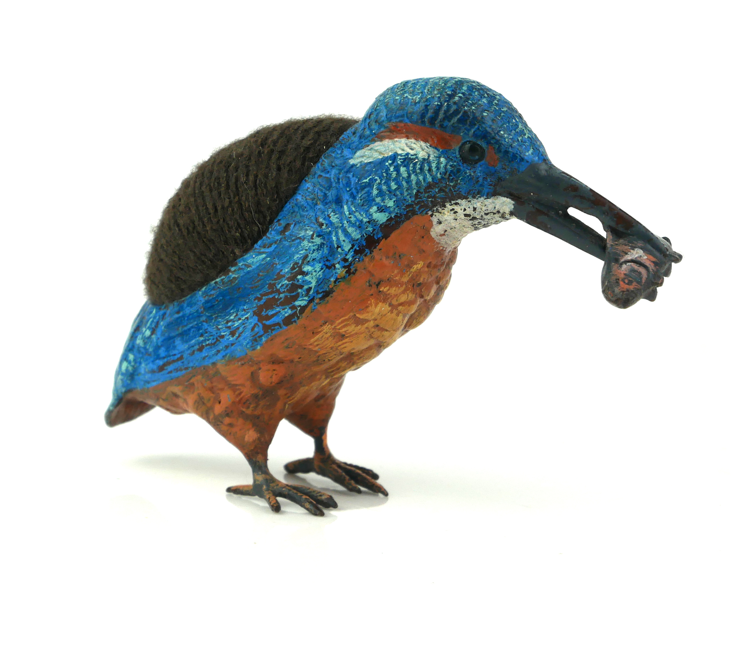 A COLD PAINTED METAL KINGFISHER With fish to beak and velvet cushion to back. (approx 14cm x 7cm)