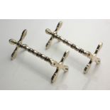 A PAIR OF SILVER KNIFE RESTS Having 'X' frame ends and shaped columns, hallmarked Birmingham,