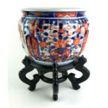 A 20TH CENTURY JAPANESE IMARI PORCELAIN JARDINIÈRE OF STAND With fluted body, underglaze blue and