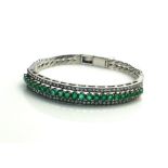 AN 18CT WHITE GOLD, EMERALD AND DIAMOND BRACELET The single row of emeralds edged with diamonds in a