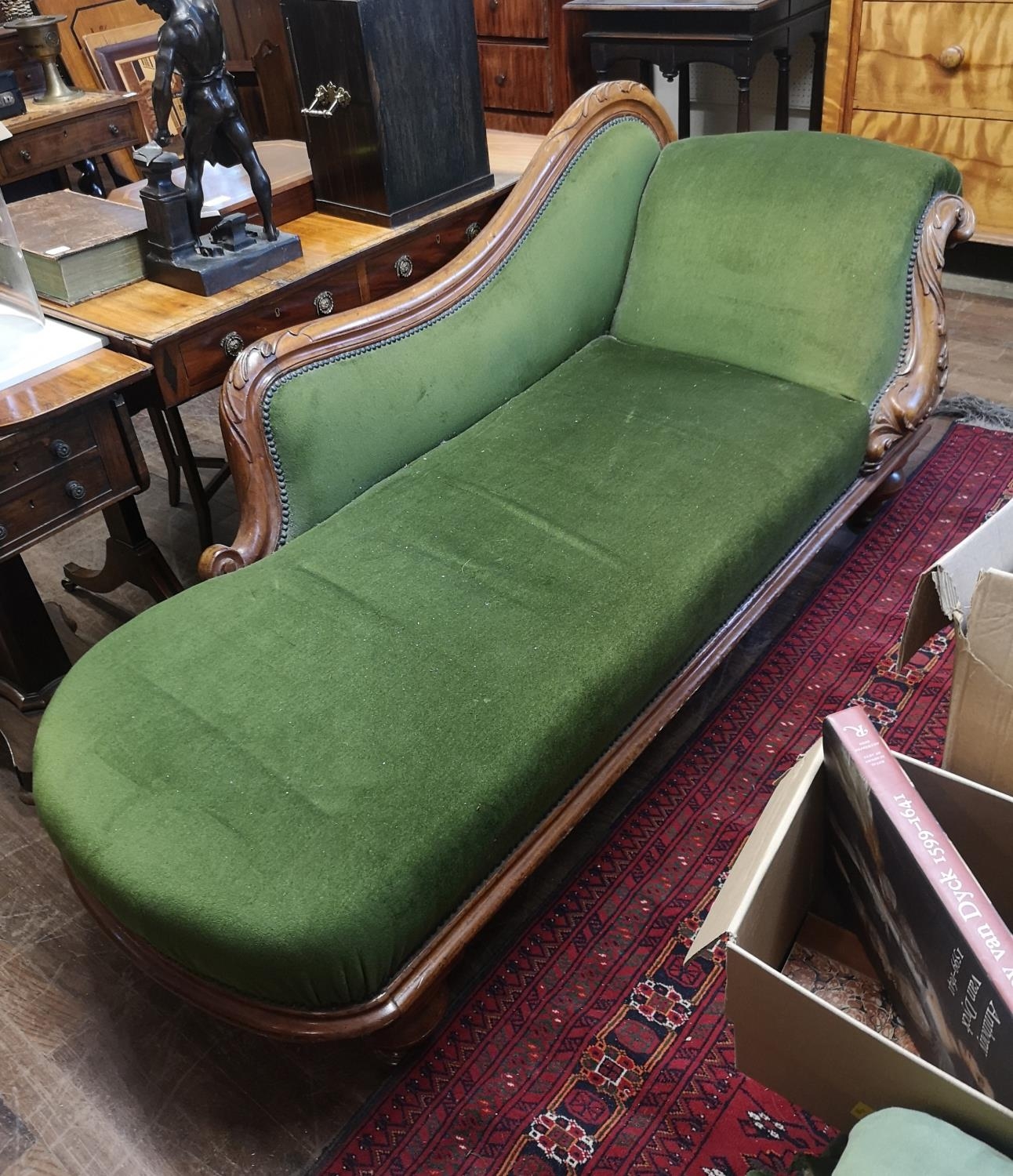 AN EARLY VICTORIAN MAHOGANY SCROLL END GREEN VELVET UPHOLSTERED CHAISE LOUNGE.