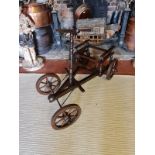 A 19TH CENTURY FRENCH FRUITWOOD PULL ALONG CART With foot steering, iron bound spoked wheels. (