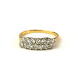 A VINTAGE YELLOW METAL AND DIAMOND RING Two rows of pavé set round cut diamonds (size K).