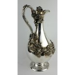 A CONTINENTAL WHITE METAL CLARET JUG, having a single handle with applied scrolling vine leaf