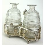 A GEORGIAN SILVER AND CUT LEAD CRYSTAL OIL AND VINEGAR CRUET SET With Dolphin form handle,