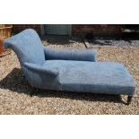 A VICTORIAN DAYBED With a single scroll arm and blue fabric upholstery, on ebonised legs. (approx
