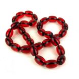 A CHERRY AMBER DESIGN NECKLACE Having a single row of uniform oval beads. (approx 41cm, each bead