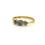 AN EARLY 20TH CENTURY 18CT GOLD AND DIAMOND THREE STONE RING Set with three graduating illusion