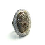 AN 18CT GOLD, DIAMOND AND CHAMPAGNE DIAMOND BOMBE RING The oval cut diamond with champagne