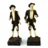 IN THE MANNER OF SIMON TROGER, AUSTRIAN, 1683 - 1768, TWO IVORY AND WALNUT FIGURES Peasants in rags.