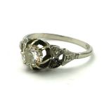 A VINTAGE PLATINUM AND DIAMOND SOLITAIRE RING Having a single round cut diamond flanked by diamond