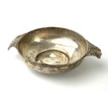 AN EDWARDIAN SILVER TWIN HANDLED CIRCULAR BOWL OF ARTS & CRAFTS FORM Having a planished finish and