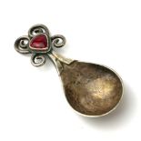 OMAR RAMSDEN, AN EARLY 20TH CENTURY SILVER AND ENAMEL CADDY SPOON Having red enamel finial and