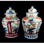 A PAIR OF CHINESE WUCAI PERIOD PORCELAIN JARS AND COVERS Both polychrome decorated with panels of