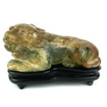 AN ANTIQUE CHINESE SOAPSTONE SCULPTURE OF A RECUMBENT LIONESS Carved decoration of protruding