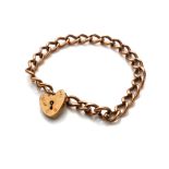 A 9CT GOLD BRACELET WITH HEART FORM LOCKET.