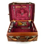 AN EARLY 20TH CENTURY SILVER FITTED LEATHER VANITY SUITCASE Comprising five silver topped glass