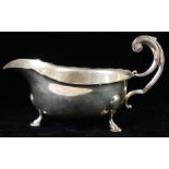 AN EARLY 20TH CENTURY SILVER SAUCE BOAT Having a scrolled handle and tripod legs, hallmarked