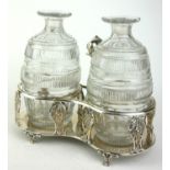 A GEORGIAN SILVER AND CUT LEAD CRYSTAL OIL AND VINEGAR CRUET SET With Dolphin form handle,