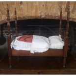 A MAHOGANY FOUR POSTER DOLLS BED With mattress, quilts and pillows. (57cm x 33cm x 60cm)