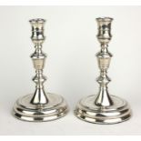 A PAIR OF GEORGE II STYLE DESK TOP HALLMARKED SILVER CANDLESTICKS With drum pattern nozzle tapered