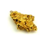 A YELLOW METAL NUGGET PENDANT Having a circular bale. (approx 3cm)