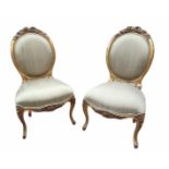 A PAIR OF 19TH CENTURY FRENCH GILT FRAMED SPOONBACK CHAIRS With carved floral cartouches,