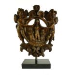 AN CARVED WOODEN CARTOUCHE IN THE MEDIEVAL STYLE Angels around saintly figures, on a museum