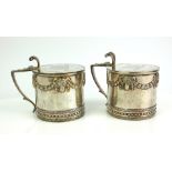 A PAIR OF VICTORIAN SILVER AND BLUE GLASS CIRCULAR MUSTARD POTS With a single handle, embossed