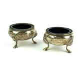 A PAIR OF GEORGIAN DESIGN SILVER AND BLUE GLASS CIRCULAR SALTS With tripod legs, hallmarked
